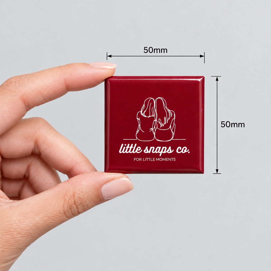 Hand holding a Little Snaps Co square magnet, with measurements showing 50 mm × 50 mm.